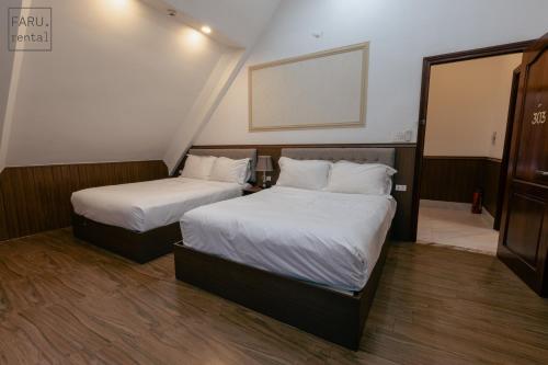 two beds in a hotel room with at Faru Pine Woods Villa in Xuan An