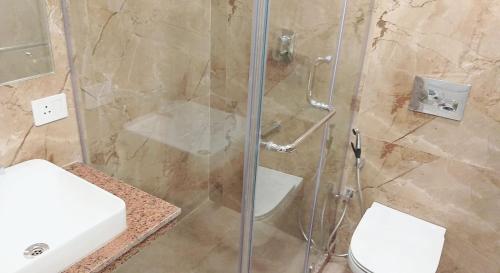 a bathroom with a shower and a toilet and a sink at Hotel Seagull in Digha