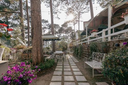a patio with chairs and tables and trees and flowers at Faru Pine Woods Villa in Xuan An