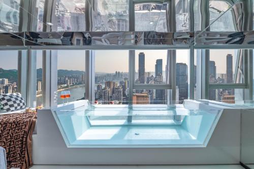 a hot tub in a room with a view of the city at 重庆Indition英迪逊高空酒店 解放碑来福士店 in Chongqing