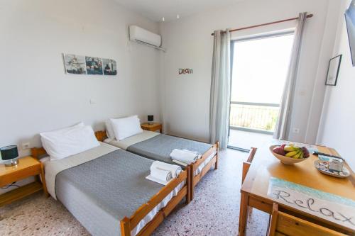 a bedroom with two beds and a table and a window at MariRena Plaz in Paralion astros