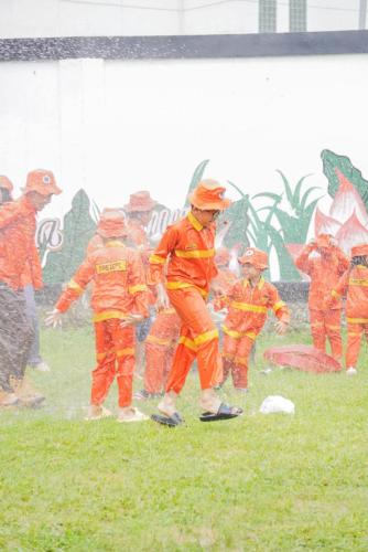 a group of firefighters in orange suits in the rain at Nemuru Grand Bhuvana Ciawi in Bogor