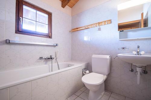 a white bathroom with a toilet and a sink at Chalet Hibou MOUNTAIN & QUIET chalet 6 pers in Veysonnaz