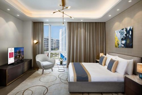 a hotel room with a bed and a chair and a television at Millennium Residences Saadiyat Island in Ḩayl