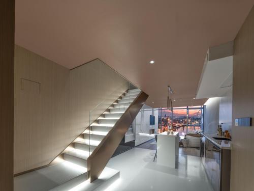 a staircase in a living room next to a kitchen at 重庆Indition英迪逊高空酒店 解放碑来福士店 in Chongqing