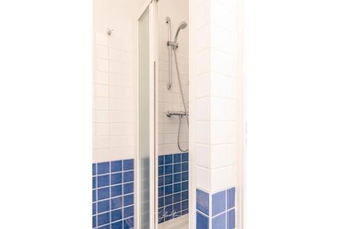 une salle de bain avec douche aux carreaux bleus et blancs dans l'établissement Acquamarina Duplex dernier étage, à Villeneuve-Loubet