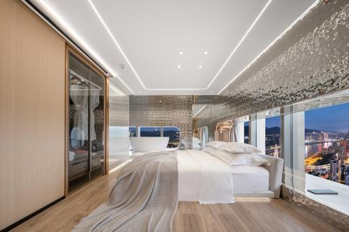 a master bedroom with a large bed and a large window at 重庆Indition英迪逊高空酒店 解放碑来福士店 in Chongqing