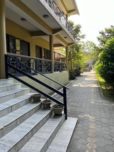 a building with stairs and a railing next to a sidewalk at Tiger Residency Resort in Sauraha