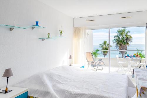une chambre avec un lit et une vue sur l'océan dans l'établissement Acquamarina Duplex dernier étage, à Villeneuve-Loubet