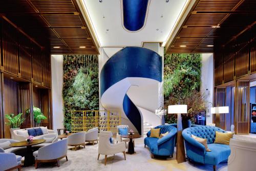 a lobby with blue and white chairs and tables at 重庆Indition英迪逊高空酒店 解放碑来福士店 in Chongqing