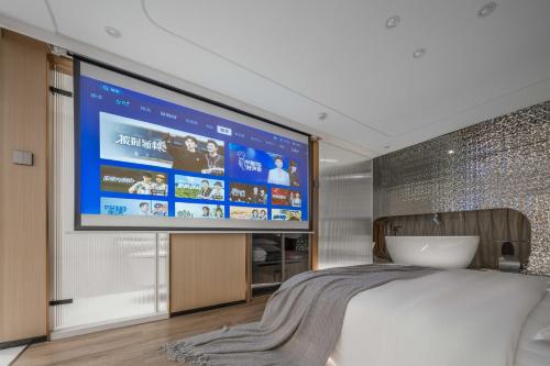 a bedroom with a large screen on the wall at 重庆Indition英迪逊高空酒店 解放碑来福士店 in Chongqing