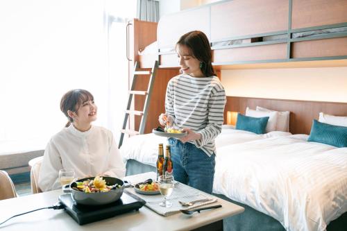 大阪市にあるなんばオリエンタルホテルのホテルの部屋に一皿を持つ女
