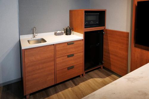 a small kitchen with a sink and a microwave at Namba Oriental Hotel in Osaka
