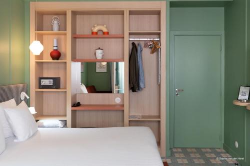 a bedroom with a white bed and a green wall at Aparthotel AMMI Nice Lafayette in Nice