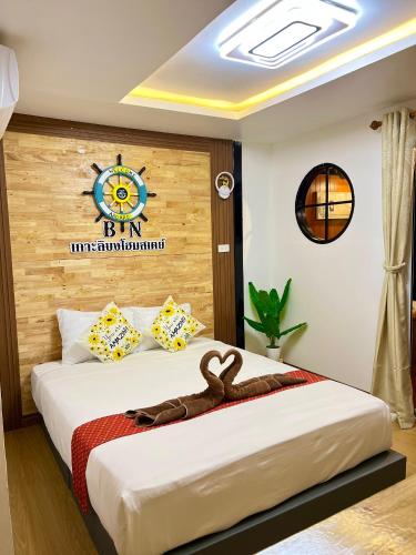 a bedroom with a bed with a clock on the wall at Bnเกาะลิบงโฮมสเตย์ in Ko Libong
