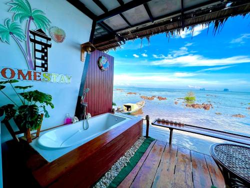 a bathroom with a tub and a view of the ocean at Bnเกาะลิบงโฮมสเตย์ in Ko Libong