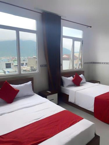 two beds in a room with two windows at LUXURY Motel in Da Nang