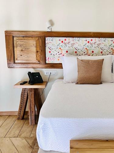 a bedroom with a bed and a table with a phone at Palazzo Matà Boutique Hotel in Taranto