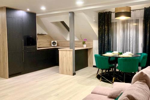 a living room with a table and green chairs at Olivia Relax & Adventure in Hliník nad Hronom