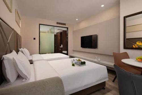 a hotel room with two beds and a table at Manston Hotel Gaoxin Science Avenue Subway Station Branch in Hefei