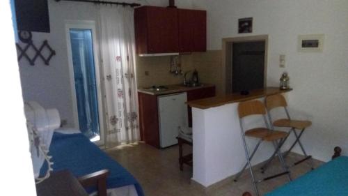 a small kitchen with a counter and a table and chairs at Kouvaras Apartments in Kýthira