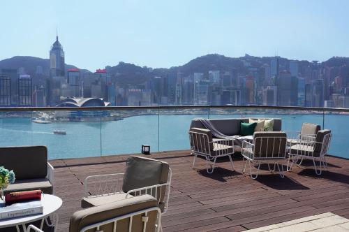 a balcony with chairs and tables and a view of a city at K11 ARTUS in Hong Kong