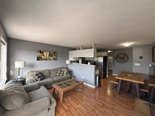 a living room with a couch and a table at Top Floor Riverfront Condo with Stellar Sunsets! in Fort McMurray