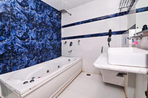 a bathroom with a tub and a sink and a bath tub at Hotel N Maharani in New Delhi