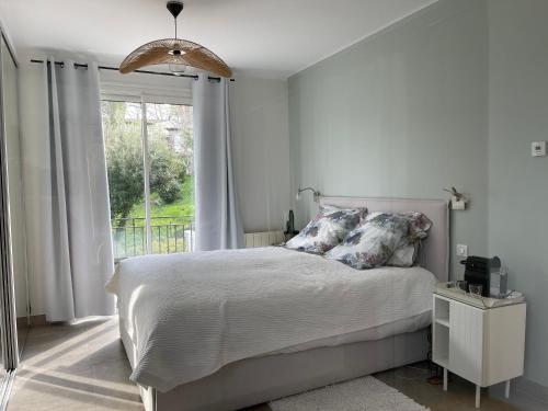 une chambre blanche avec un lit et une fenêtre dans l'établissement Villa avec piscine à 5 min du Golf et 15 min des plages, à Biot
