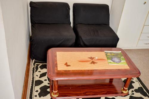 a coffee table in front of a chair and a couch at Crystal Palace Hotel in Gaborone