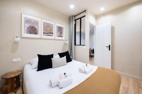 une chambre avec un lit blanc avec deux serviettes dessus dans l'établissement Le Marais l 5BR & AC - Duplex Home in Paris, à Paris