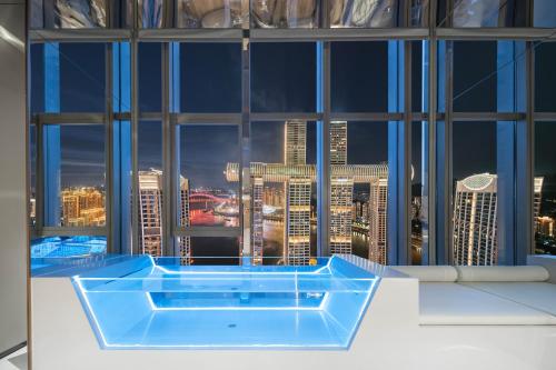 a bath tub in a room with a view of a city at 重庆Indition英迪逊高空酒店 解放碑来福士店 in Chongqing