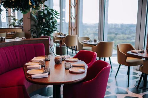a table and chairs in a restaurant with a view at nhow Amsterdam Rai in Amsterdam