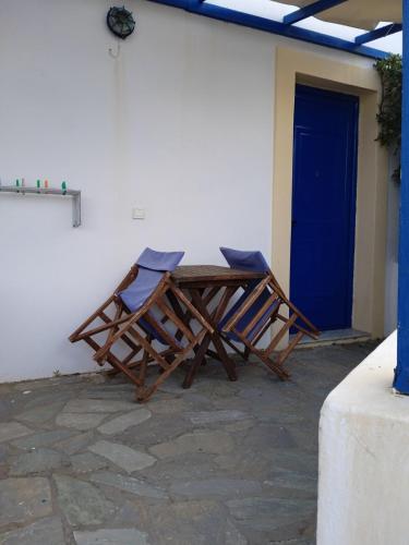 a wooden table and chairs sitting outside of a building at Kouvaras Apartments in Kýthira