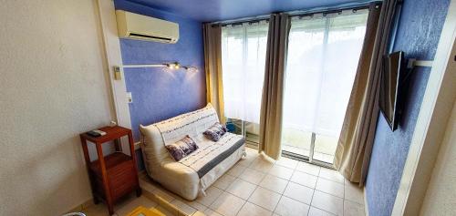 un salon avec un canapé et une grande fenêtre dans l'établissement PORT CAMARGUE Studio vue mer, au Grau-du-Roi