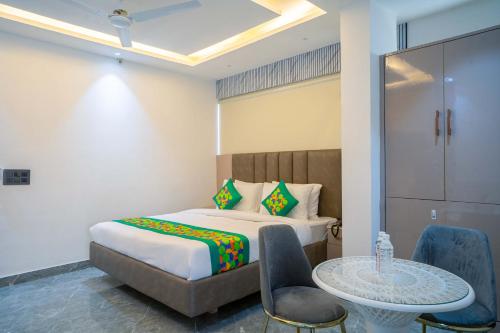 a bedroom with a bed and a table and chairs at Treebo Gemstone in New Delhi