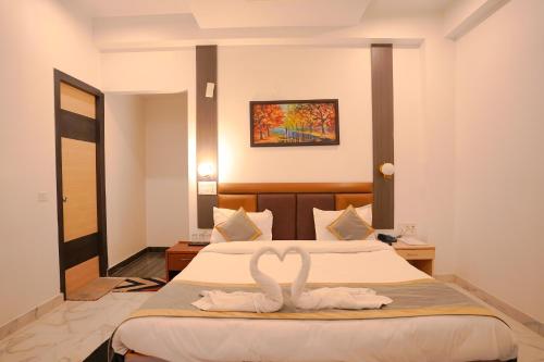 a bedroom with two swans towels on a bed at Chirping Hills Resort,Bhimtal in Bhīm Tāl