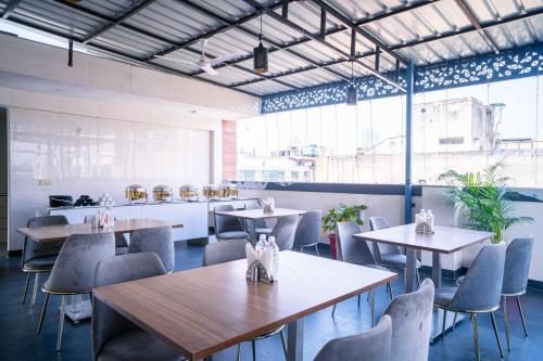a restaurant with tables and chairs in a room at Treebo Gemstone in New Delhi