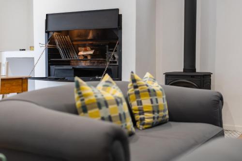 a couch with two pillows in front of a fireplace at Cherry Blossom in Ceres