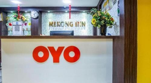 a sign for a meeting inn with a clock and flowers at OYO 90173 Hotel Mekong in Kuala Lumpur