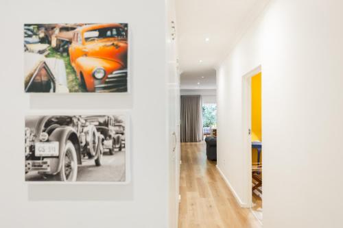 a living room with two pictures of cars on the wall at Cherry Blossom in Ceres