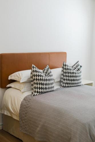 a bed with three pillows on top of it at Cherry Blossom in Ceres