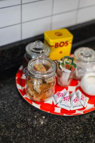 a plate with a jar of food and some cookies at Cherry Blossom in Ceres