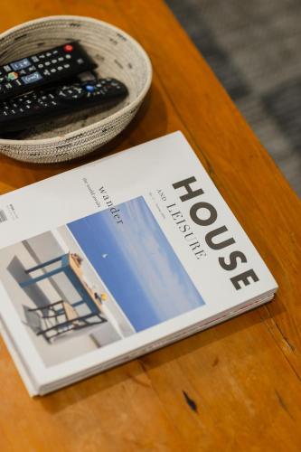 a magazine sitting on a table next to a remote control at Cherry Blossom in Ceres