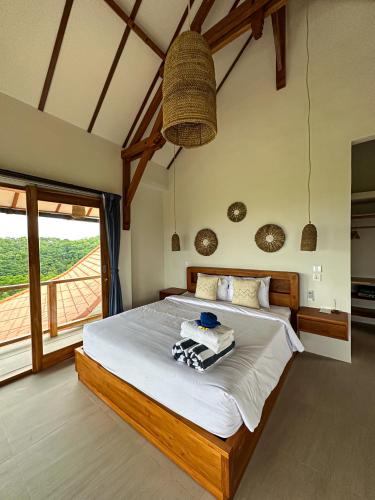 a bedroom with a large bed and a large window at Villa Treetop, 2BR with spectacular ocean view in Nusa Penida