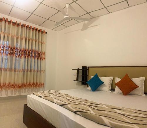 a bedroom with a large bed with colorful pillows at Cozy home in Badulla
