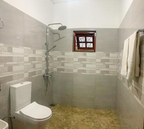a bathroom with a toilet and a window at Cozy home in Badulla