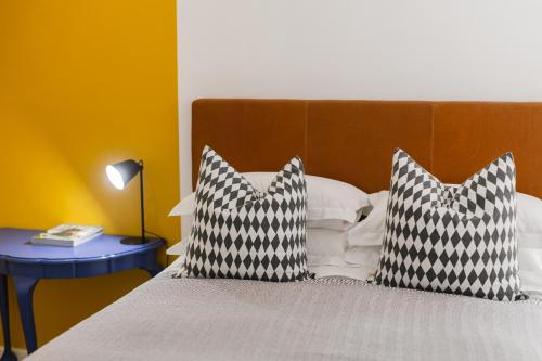 a bed with two black and white pillows on it at Cherry Blossom in Ceres