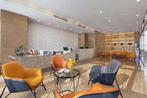 a waiting room with orange chairs and a counter at Manston Hotel Gaoxin Science Avenue Subway Station Branch in Hefei