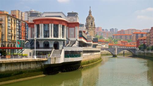 a river with a building next to a bridge at Confortable piso en el Puerto Viejo de Algorta, a 7 min de la playa in Getxo